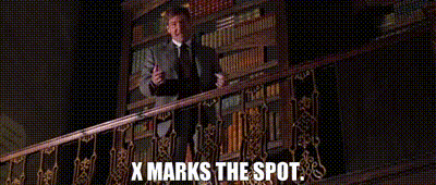 Indy stands on a library balcony and says "X marks the spot."