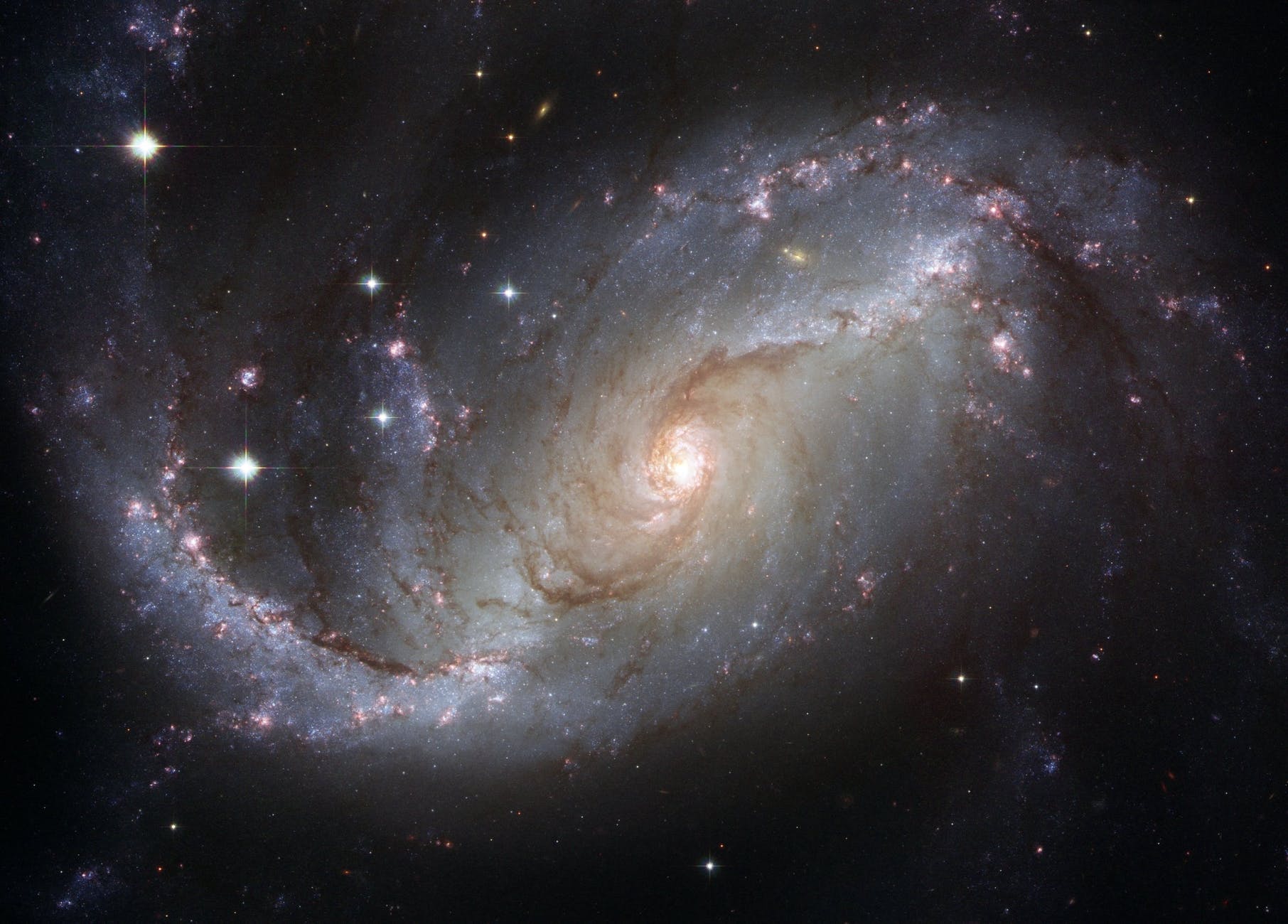 An image of a white and cream-colored spiral galaxy spangled with stars in the black, perhaps our own Milky Way.
