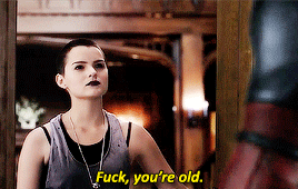 A young person with a buzzcut, black lipstick, perfect eyebrows, and immaculate queer aesthetic (Brianna Hildebrand as Negasonic Teenage Warhead) says "fuck you're old" to Deadpool
